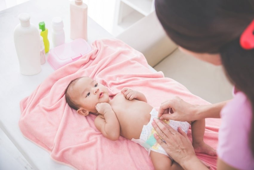 matka mění dětskou plenku's diaper