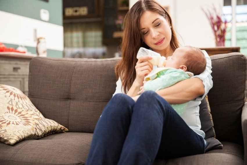 a mãe a alimentar o seu bebé com biberão